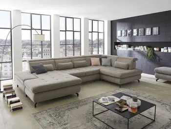 Beige Wohnlandschaft mit vielen Kissen in unterschiedlichen Farben in einem Loft.